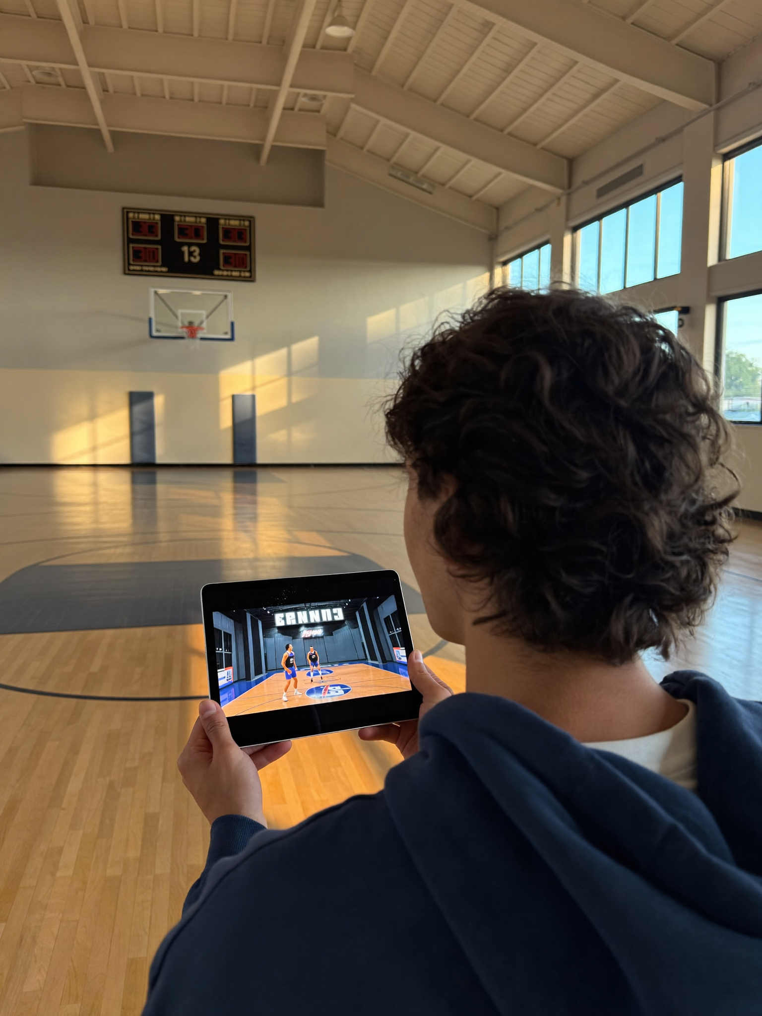 An athlete reviewing game film courtside at dawn