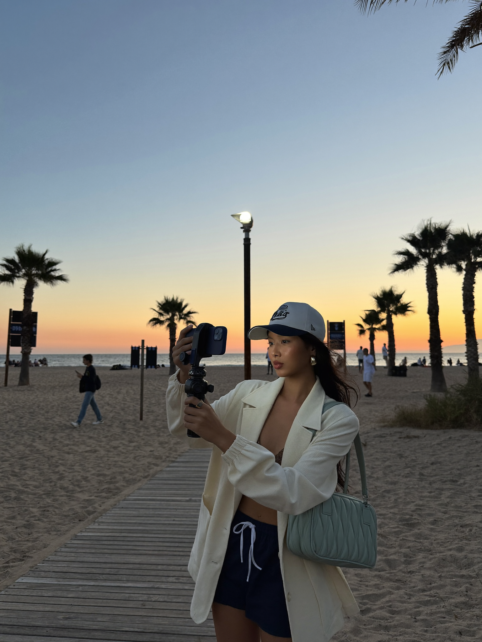 A creator filming UGC content on a Los Angeles boardwalk at sunset