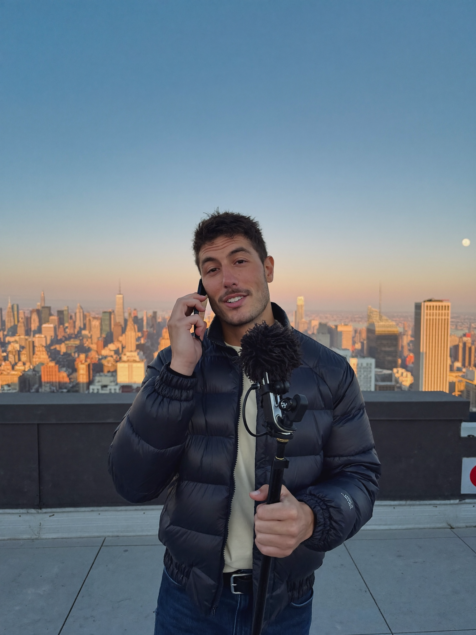 A builder recording a talking-head video on a New York rooftop at dawn
